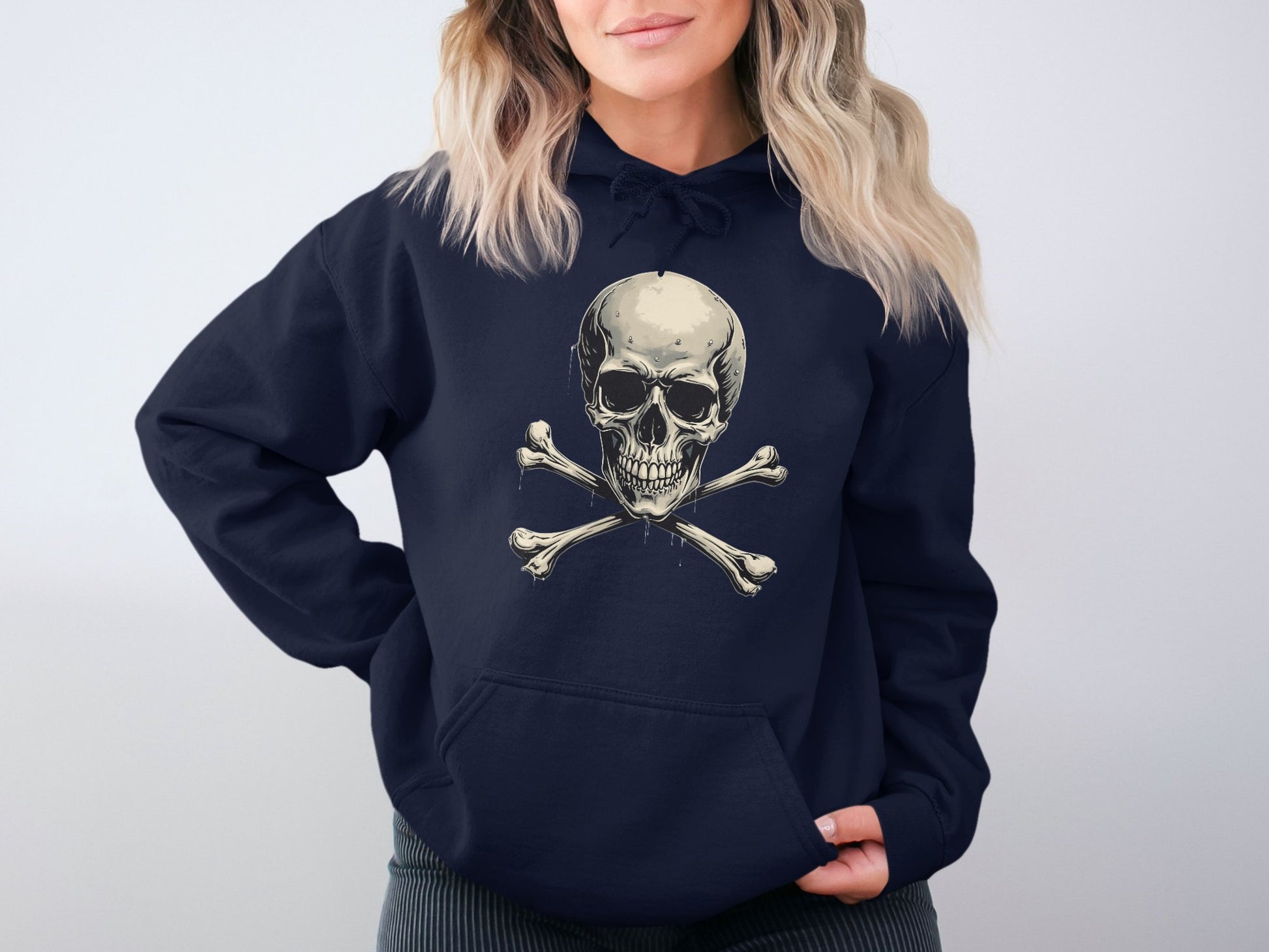 A person wearing Garment Graphics dark streetwear hoodie with a striking skull and crossbones graphic on the front, set against a plain, neutral background that highlights the edgy vibe of this stylish hoodie.