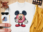 A white Garment Graphics sweatshirt featuring a donut character like a famous mouse lies flat with fun accessories: sunglasses, makeup brushes, a yellow jacket, pink shoes, and makeup items on a wooden surface. Unisex sizing ensures perfect comfort and style.