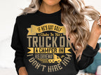 A woman wears a black Garment Graphics sweatshirt with the humorous text: If he’s got golf clubs in his truck or a camper in his driveway, I don’t hire him, and graphics including a small truck. With long, wavy hair, she gently touches it with her left hand.