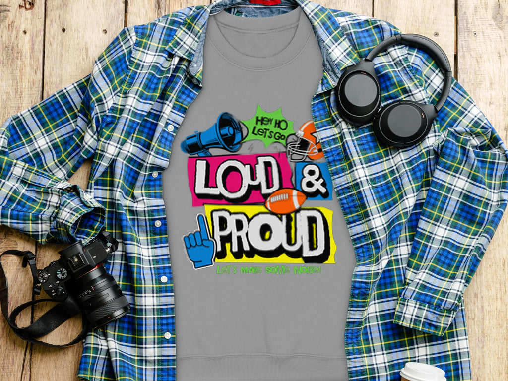 A unisex gray T-shirt from Garment Graphics features colorful Loud & Proud and Hey! Yo Lets Go! Thats How Youre Heard text with images of a megaphone, sunglasses, and sports gear. Ideal for any occasion, this unique piece is perfect for fans of Loud and Proud Sweatshirts.
