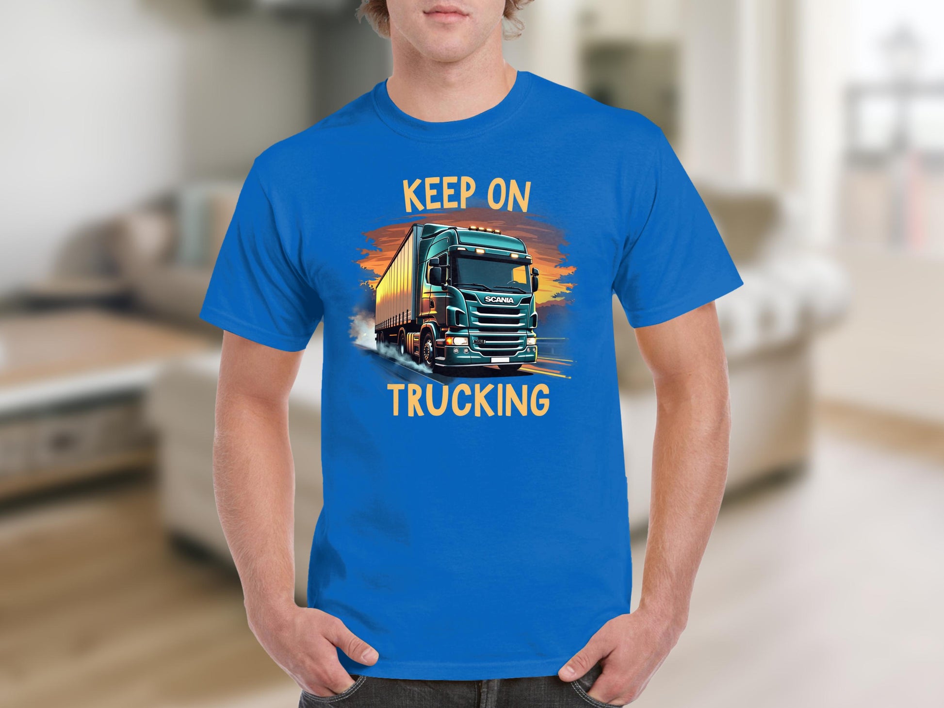 Someone is sporting a Garment Graphics blue graphic tee featuring a large truck and bold KEEP ON TRUCKING text, ideal for truck lovers.