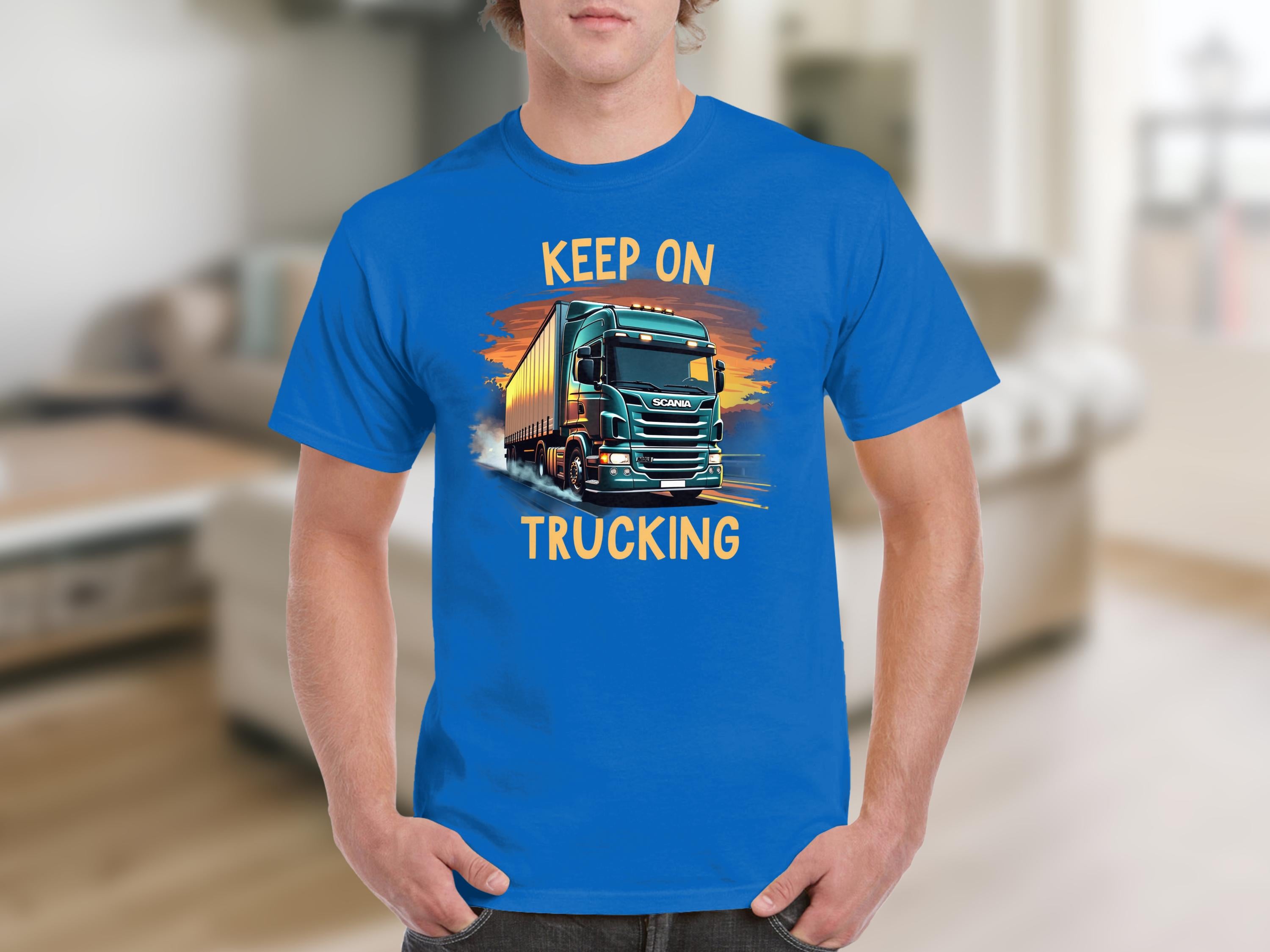 Someone is sporting a Garment Graphics blue graphic tee featuring a large truck and bold KEEP ON TRUCKING text, ideal for truck lovers.