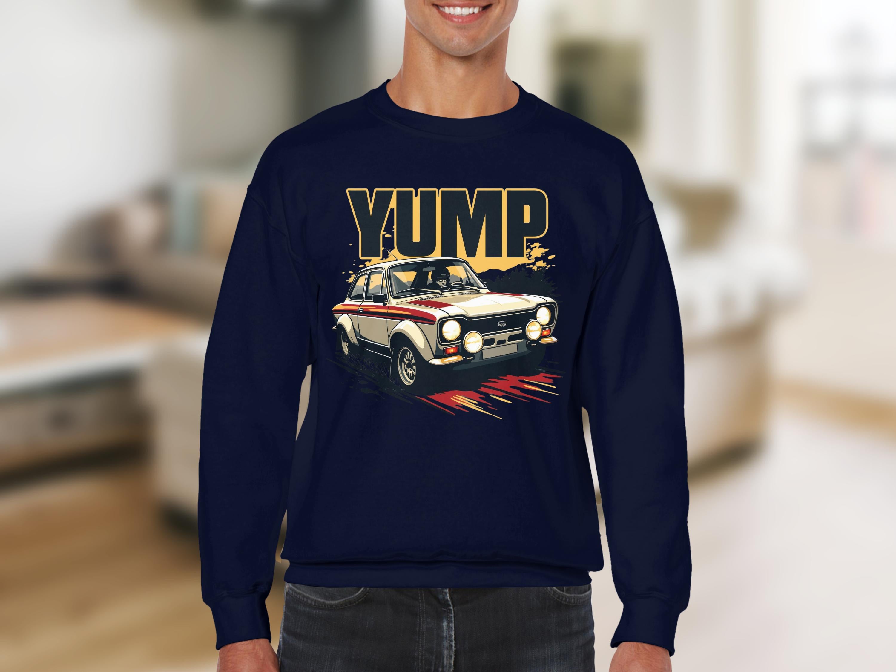 A man in a Garment Graphics navy sweatshirt with a rally car graphic and bold YUMP design stands against a blurred interior.