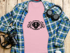 A Garment Graphics pink T-shirt with Scania Power Eagle and number 8 lies on a wooden surface, partly covered by a blue-green plaid shirt. Nearby, stylish essentials—headphones, a DSLR camera, and a white coffee cup—are artfully arranged.