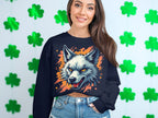 In front of a shamrock-covered wall, a person showcases their wild side wearing Garment Graphics black sweatshirt featuring a fierce wolf design. Its paired with blue jeans, and their long brown hair cascades over the shoulders.