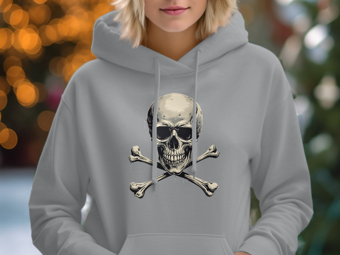 A white Garment Graphics streetwear hoodie featuring a skull and crossbones design is displayed on a wooden surface. Its surrounded by essentials like a notebook, sunglasses, hat, dark sandals, wicker bag, and instant camera—perfect for any casual day in style.