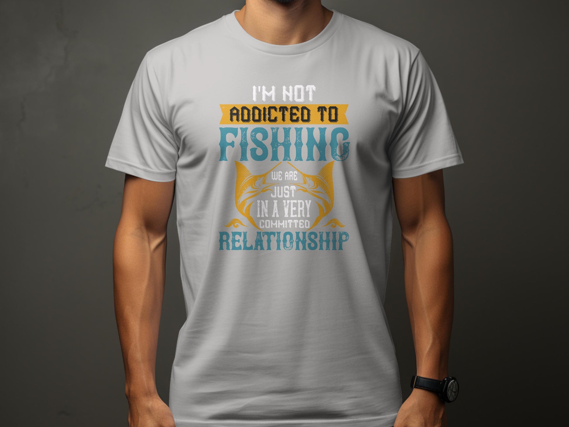 A person in a light grey Garment Graphics Fishing T-shirt sports the phrase Im not addicted to fishing. We are just in a very committed relationship with stylized fonts, standing casually with relaxed arms and wearing a watch on the left wrist, ideal for passionate anglers.