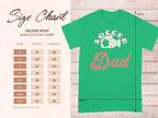 Garment Graphics presents a green graphic Soccer Dad T-shirt with a soccer ball design. Displayed on wood, it includes a Gildan 5000 heavy cotton tee size chart, available in sizes S to 5XL (in inches). Ideal for any proud dad who loves soccer.