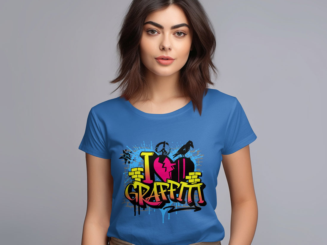 A woman with long brown hair dons a blue Garment Graphics T-shirt featuring vibrant street art and the phrase I Love Graffiti in stylized letters, standing against a plain light gray backdrop and embodying urban design spirit.