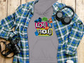 A bold gray hoodie from Garment Graphics features Loud & Proud in vibrant colors, styled with a plaid shirt, headphones, camera, and coffee cup on wood—perfect for Lets Make Some Noise Hoodies vibes.