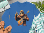 A Garment Graphics blue sweatshirt showcases a rocking gorilla with sunglasses, electric guitar, and peace sign. Ideal for music enthusiasts, it complements sandals, a striped shirt, and a watch. It includes practical accessories like a pen and light-colored bag for the perfect ensemble.
.