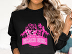 A person with wavy, long blonde hair is wearing a black sweatshirt from Garment Graphics featuring a pink graphic of stylized women, palm trees, and the text Always Party Beach Girl.