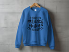 A quirky Garment Graphics sweatshirt in unisex sizing hangs on a wooden hanger against a concrete wall, featuring the bold message, I HAD MY PATIENCE TESTED IM NEGATIVE, making it perfect for adding humor to casual outings.