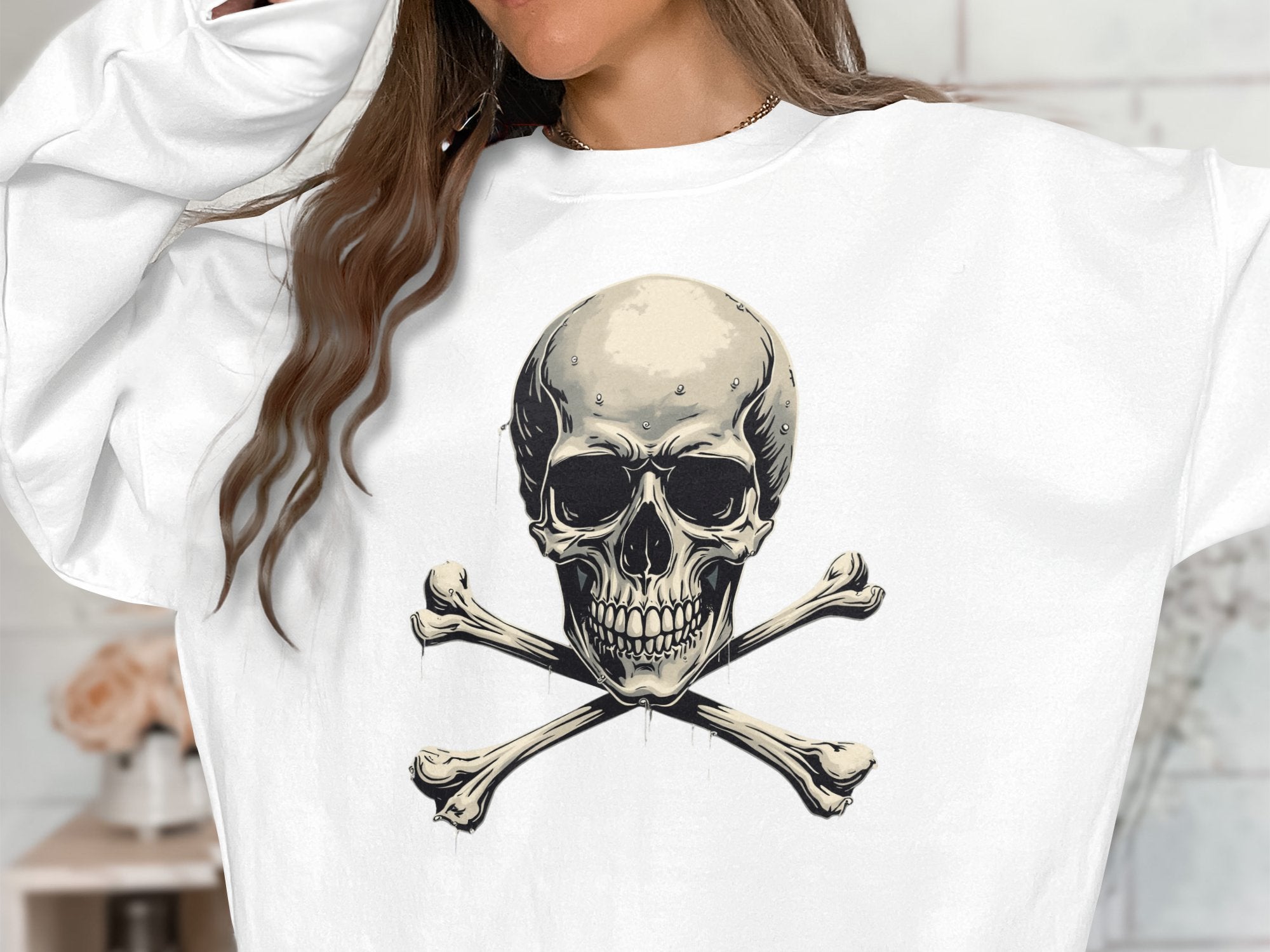 A person wears Garment Graphics unisex white sweatshirt featuring an edgy skull and crossbones on the front, with long, wavy hair partially out of frame.