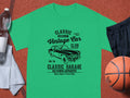 A Garment Graphics green t-shirt with Classic London City Vintage Car Club. Custom Culture. Classic Garage. Old School Automotive is displayed with a basketball, water bottle, striped towel, and black shorts on a sports court, ideal for vintage car fans.