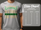 Someone wears a light gray Garment Graphics Gildan 5000 heavy cotton T-shirt with the witty design: If an Englishman gets run down by a truck, he apologizes to the truck. A size chart on the right provides sizes S-5XL with width and length in inches.