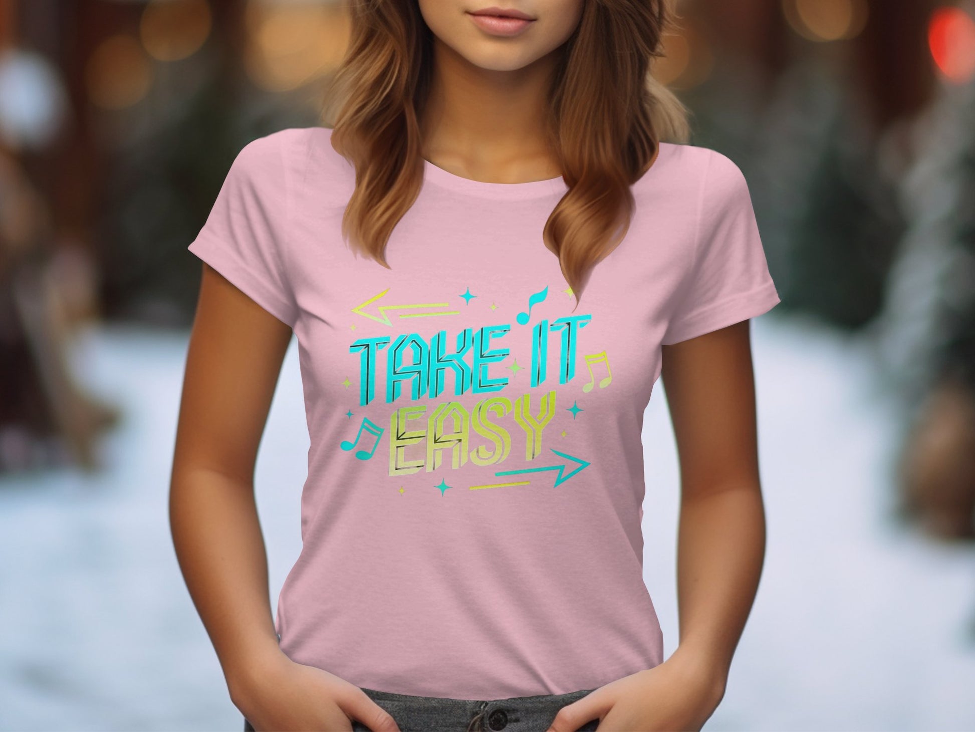 A person wearing a light pink Take It Easy T-shirt from Garment Graphics showcases a stylish design with vibrant musical notes and arrows, against a blurred snowy tree background.