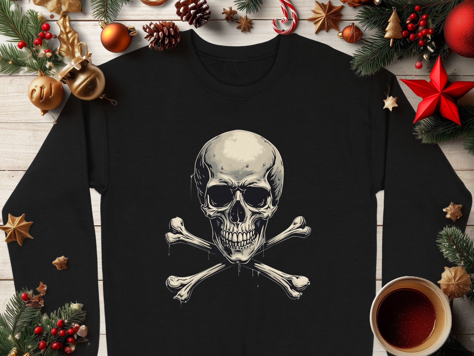 A Garment Graphics black long-sleeve shirt with a skull and crossbones design is styled on a wooden surface with festive decorations, including pine branches, pinecones, orange slices, a candy cane, ornaments, and a cup of black coffee.