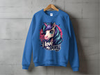 A blue Garment Graphics sweatshirt features a vibrant pony-unicorn design with large eyes and a flowing mane, accompanied by the text I love my pony, hanging against a concrete wall.