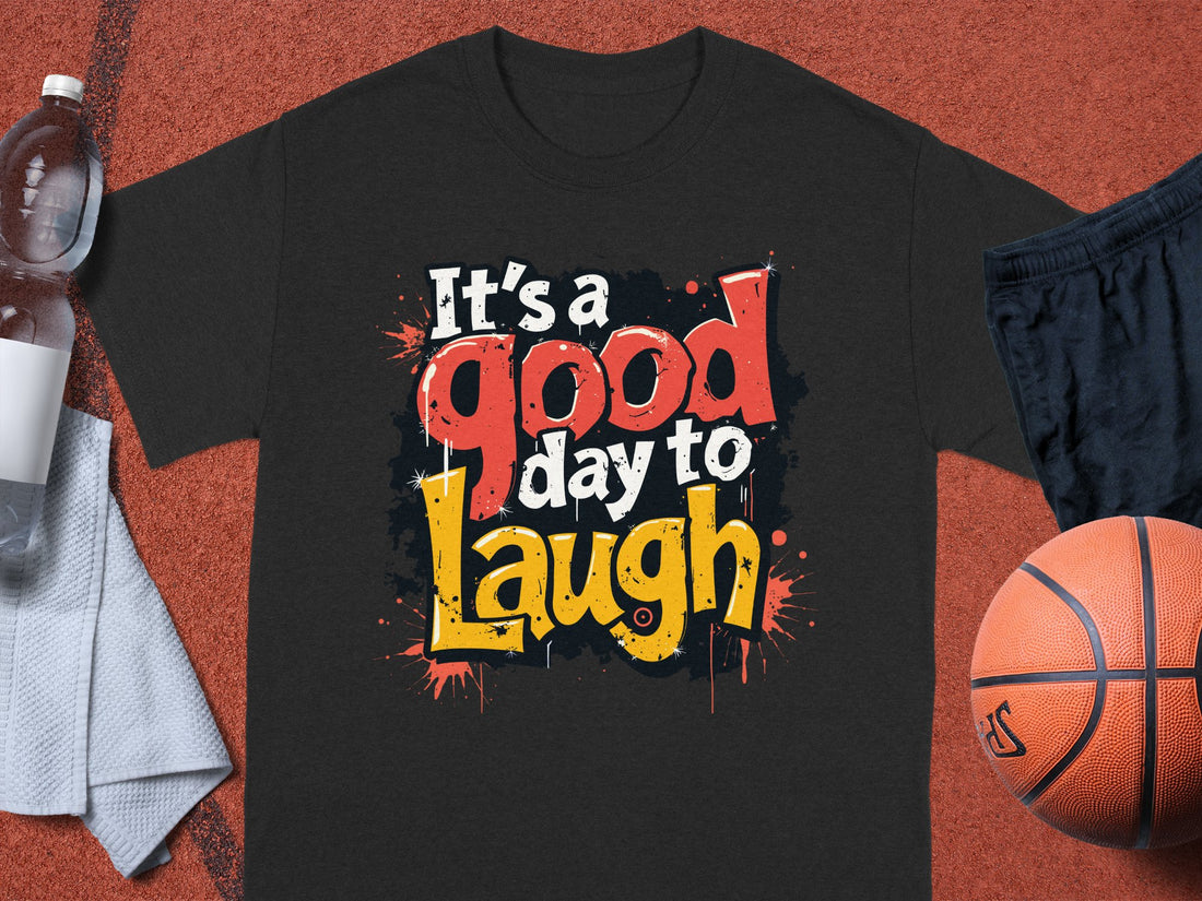 Wearing a Garment Graphics Its a Good Day to Laugh T-shirt, a person casually stands with hands in pockets. The shirts vibrant colors amplify the relaxed, outdoor vibe against sandy beach and grassy dunes.