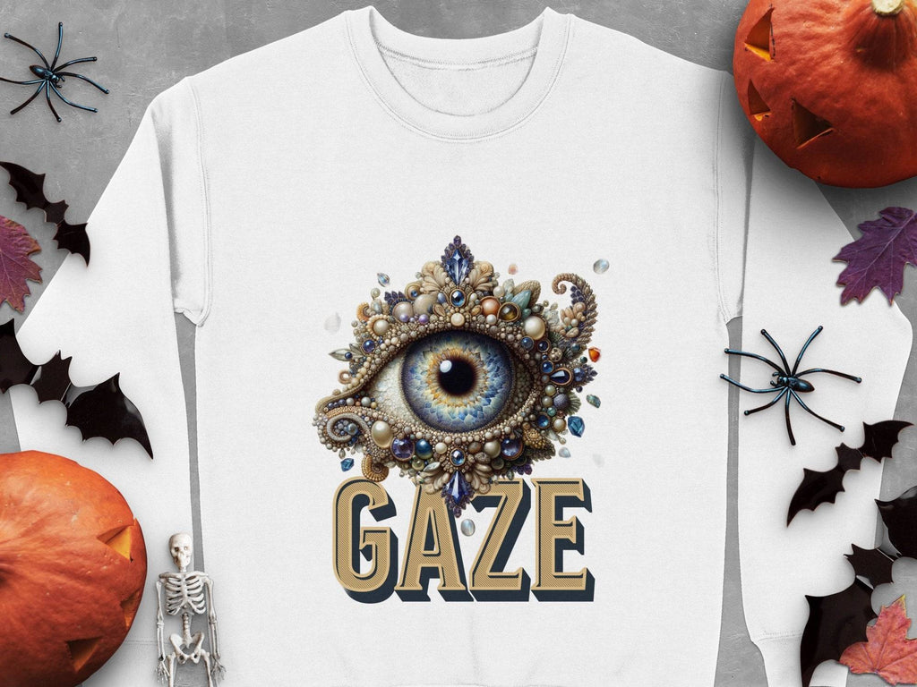 Garment Graphics presents a white sweatshirt with a jewel-encrusted eye above GAZE, surrounded by bats, spiders, black leaves, a skeleton, and jack-o-lanterns on a gray background. Available in unisex sizes, its a timeless style staple.