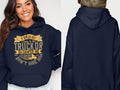 Front and back views of a navy golf hoodie by Garment Graphics. The front shows the humorous gold text: If hes got golf clubs in his truck or a camper in his driveway, I dont hire him. A smiling woman models it. The plain back makes it an ideal gift for those with a sense of humor.
.