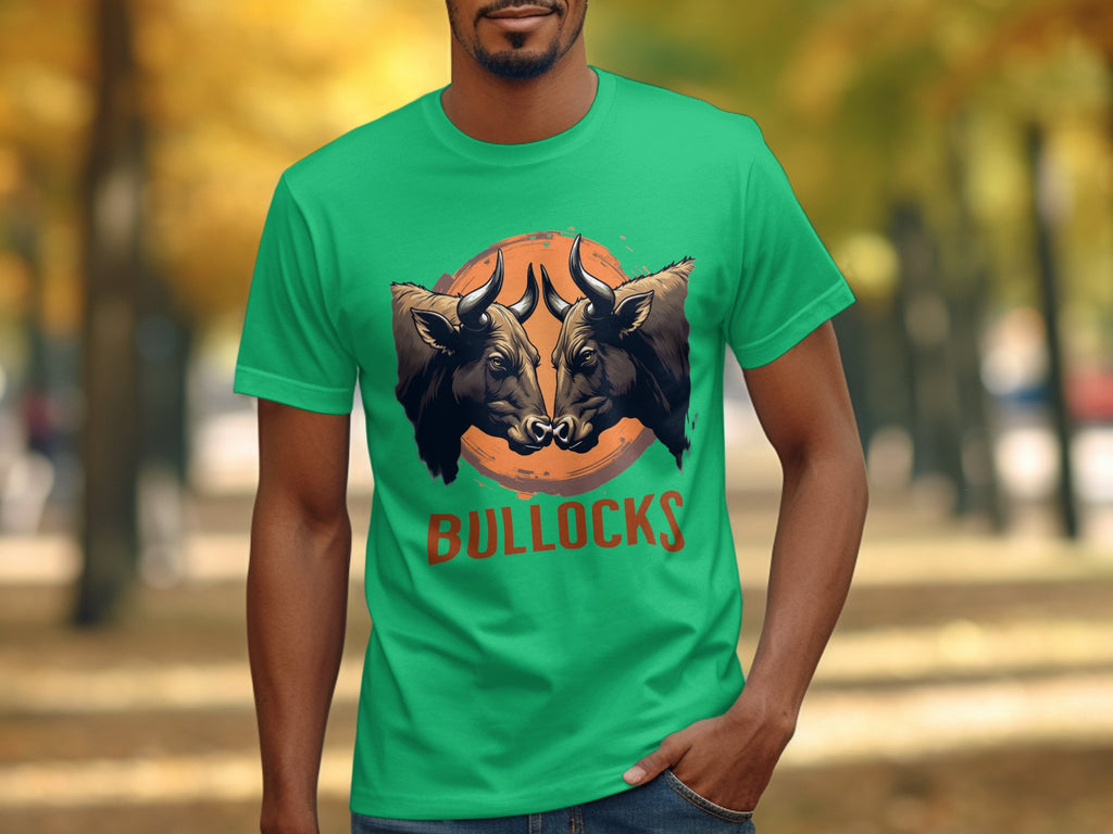 A person wears a Garment Graphics classic fit green T-shirt with two angry bulls facing each other above BULLOCKS. Theyre in a park with vibrant autumn trees, ideal for family outings and flaunting your Bullocks Pintable T-Shirts style.