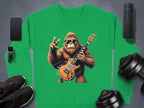 Garment Graphics offers a green rocking gorilla sweatshirt with a gorilla in sunglasses, holding an electric guitar and flashing a peace sign. Ideal for stylish music lovers; nearby items include smartphone, wireless speaker, smartwatch, black shoes, and dumbbells.