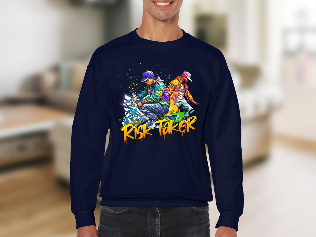 A person is wearing a dark blue Garment Graphics sweatshirt featuring a vibrant design of two figures in colorful street dance attire. Below the artwork, the text Risk Taker Street Dance captures the spirit of fearless competition.