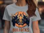 A person is wearing a Garment Graphics t-shirt with two bulls facing each other in an orange circle, BULLOCKS printed boldly below. The background is blurred, enhancing this striking casual wear.