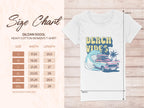 The Garment Graphics Gildan 5000L t-shirt features a retro surf design with Beach Vibes, showcasing a pink car, surfboard, palm trees, and wave on a white tee. The background has a subtle leaf pattern. Size chart available for S to 3XL with measurements in inches.