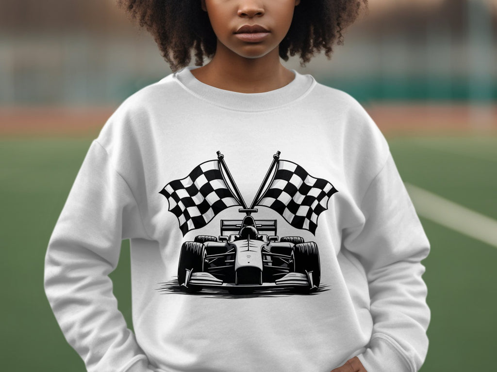 A person sports a Garment Graphics racing car sweatshirt with a black and white illustration of a race car and crossed checkered flags, against a blurred sports field backdrop.