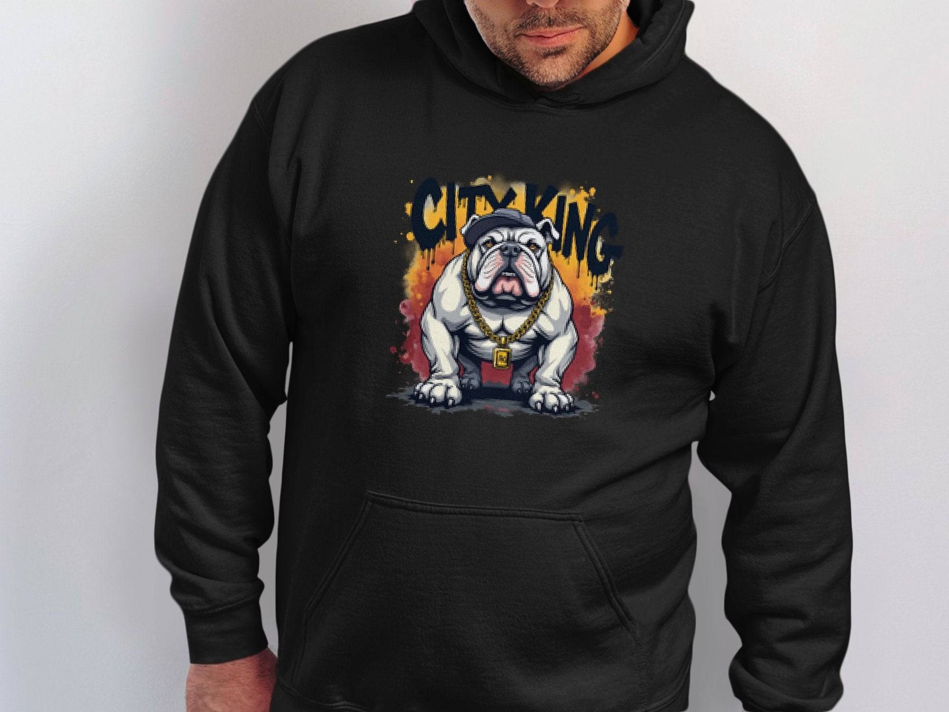 A person wears a classic black hoodie from Garment Graphics with a graphic bulldog design sporting a gold chain. The text CITY KING is above the dog, making it an essential addition to any casual wardrobe.