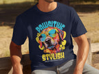 Seated on a wooden bench, a person wears a navy blue dog t-shirt by Garment Graphics featuring a colorful graphic of a dog in sunglasses. The playful phrases Paw-sitive Stylish and Chillin Like A Canine Villain are printed boldly, highlighting the essence of canine coolness.