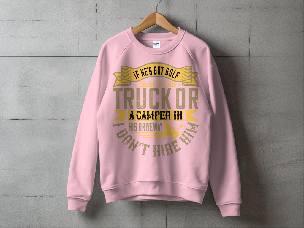 A pink Garment Graphics sweatshirt on a wooden hanger against a concrete wall features bold gold and white text: If hes got golf clubs in his truck or a camper in his driveway I dont hire him, capturing the whimsical essence of the outdoors.