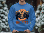 A person wears a Garment Graphics unisex bull graphic sweatshirt featuring two bull heads against an orange circle, with BULLOCKS boldly displayed over a snowy scene with blurred trees.