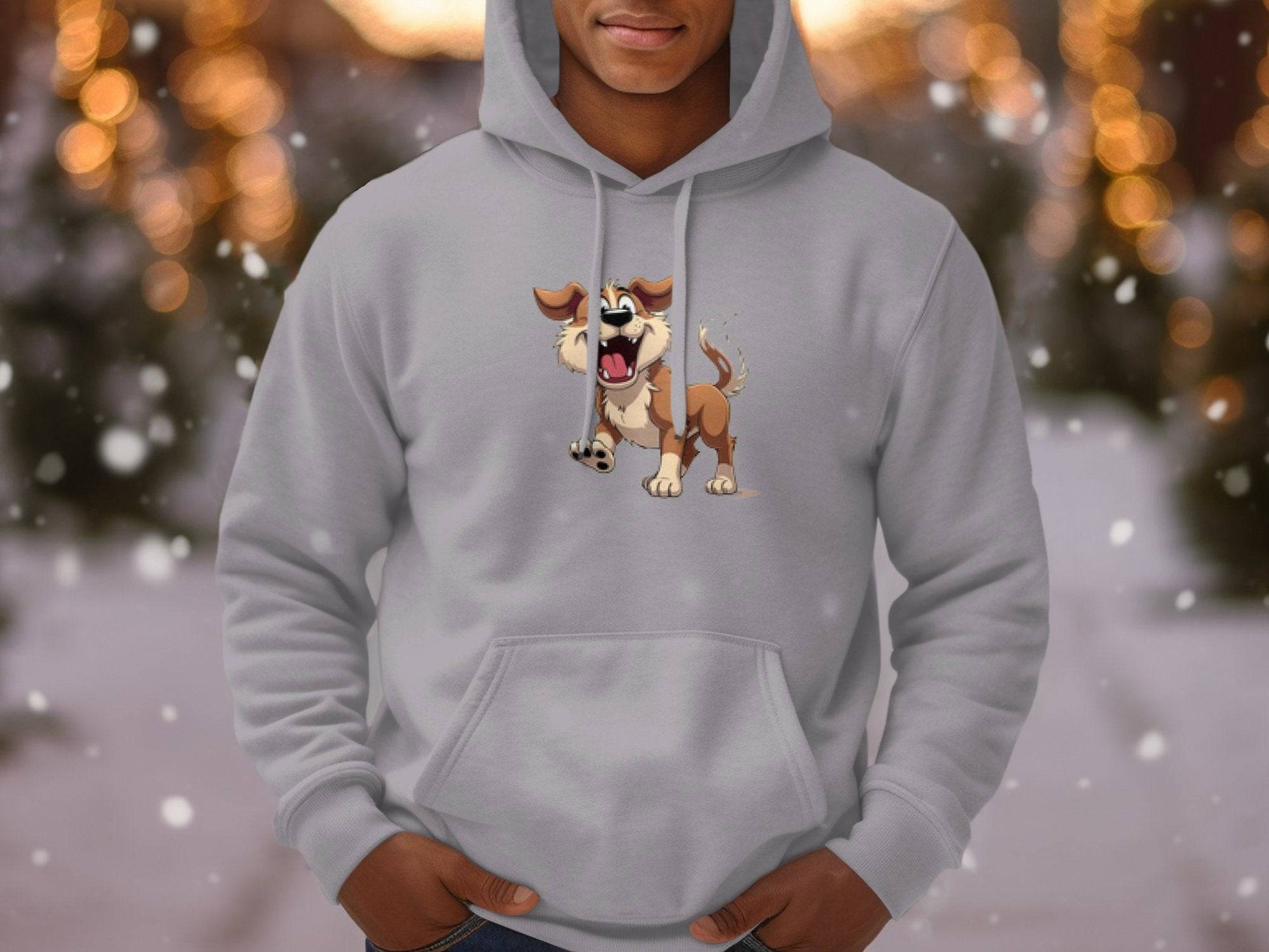 A person in a gray cartoon puppy hoodie by Garment Graphics stands outdoors amid a winter wonderland, with blurred snowflakes and lights in the background. An ideal choice for dog lovers, this fun piece captures playful charm.