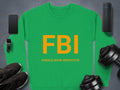 A vibrant unisex sweatshirt by Garment Graphics showcases a bold design: green with FBI in yellow and FEMALE BOOB INSPECTOR beneath. Surrounding it are a smartphone, smartwatch, sneakers, dumbbells, and a speaker on gray.