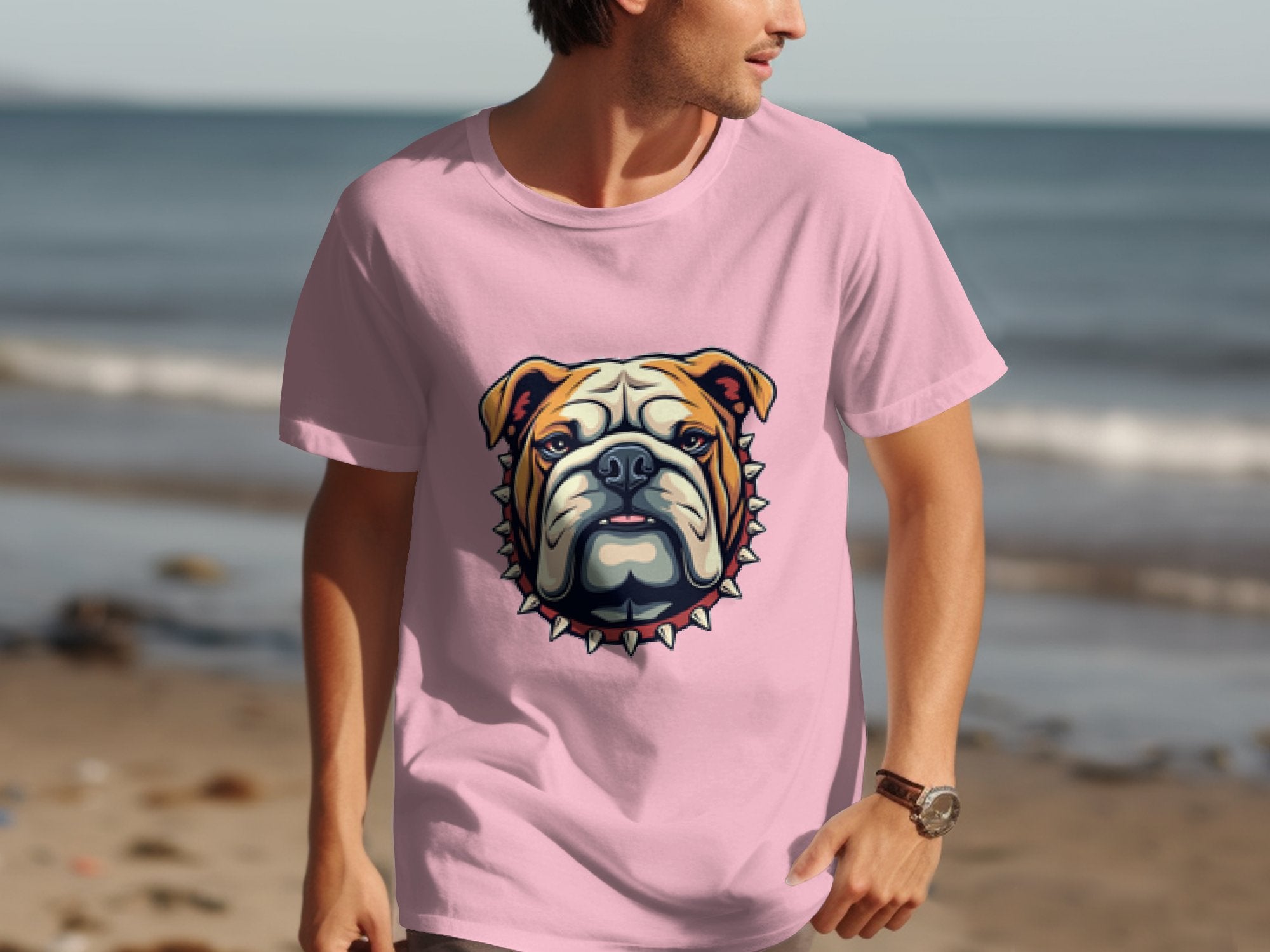 A person in a vibrant pink Garment Graphics T-shirt with a bold bulldog design stands on the beach, facing sideways. The ocean and sand extend behind them, ideal for family sizing adventures.