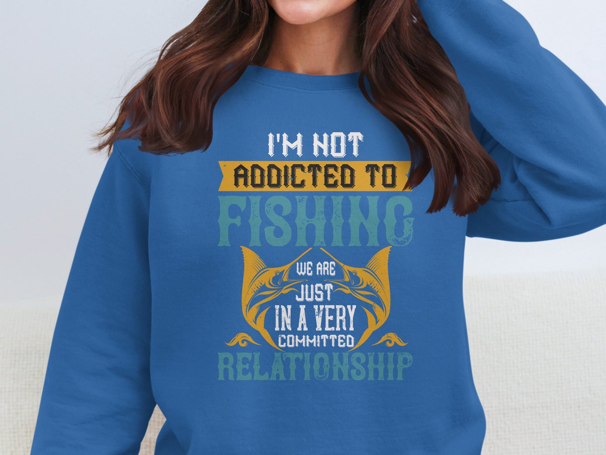 The unisex sweatshirt by Garment Graphics showcases a witty design with text, Im not addicted to fishing. We are just in a very committed relationship, alongside two fish facing each other.