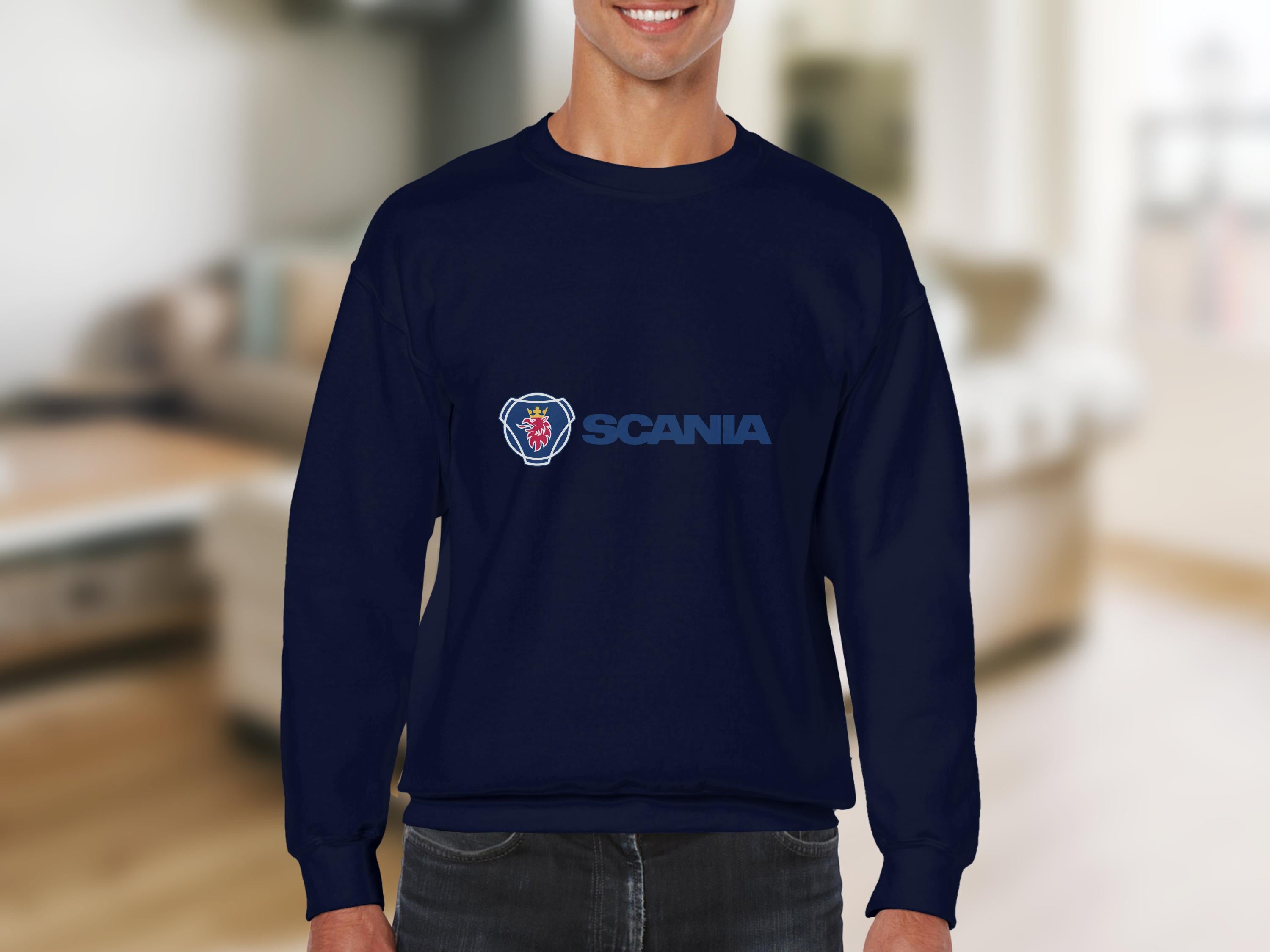A person wearing a navy Scania logo sweatshirt from Garment Graphics stands indoors, surrounded by soft lighting and neutral decor. The unisex sizing makes it ideal for casual outings while keeping their face unseen and emphasizing comfort.