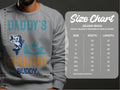 A person proudly wears a Garment Graphics Daddys Fishing Buddy sweatshirt, ideal for outdoor lovers with a fish and boat design. Next to them, a size chart for the Gildan 18000 outlines sizes from S to 5XL with exact width and length details.