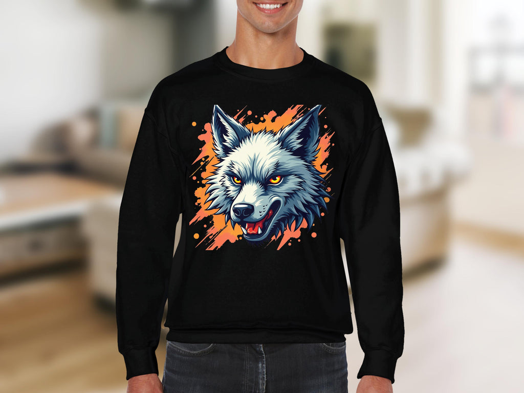 A person wears a Garment Graphics black sweatshirt with a graffiti-style snarling wolfs head graphic, complete with sharp teeth and vivid yellow eyes on an orange splattered background. They are in a living room with blurred furniture, enhancing the sweatshirts unique flair.
