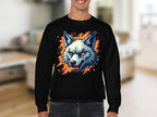 A person wears a Garment Graphics black sweatshirt with a graffiti-style snarling wolfs head graphic, complete with sharp teeth and vivid yellow eyes on an orange splattered background. They are in a living room with blurred furniture, enhancing the sweatshirts unique flair.