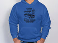 Wearing Garment Graphics blue hoodie, featuring a vintage London car design with Vintage Car Club and Classic Garage, an auto enthusiast stands with hands in pockets. The classic fit perfectly complements their style.