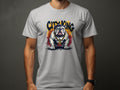 A person in a gray Garment Graphics T-shirt showcases unique style with a cartoon bulldog wearing a crown. The words City King majestically hover above against a plain background as they stand confidently with arms down.