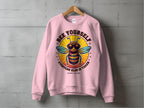 Garment Graphics pink unisex sweatshirt features a bee in sunglasses with the text Bee Yourself, Everyone Else Is Taken and Summer Edition, stylishly displayed against a concrete wall.