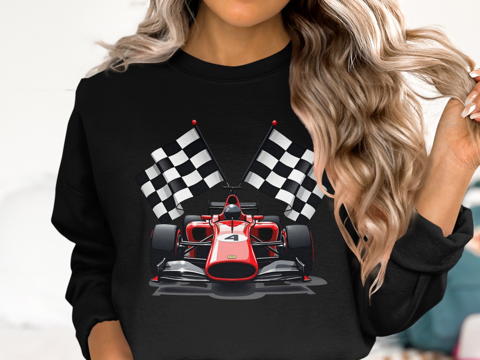 Someone with long wavy hair is wearing a vibrant black sweatshirt from Garment Graphics featuring a graphic of a red Formula 1 racing car and the number 4, framed by two black and white checkered flags, ideal for motorsport fans.