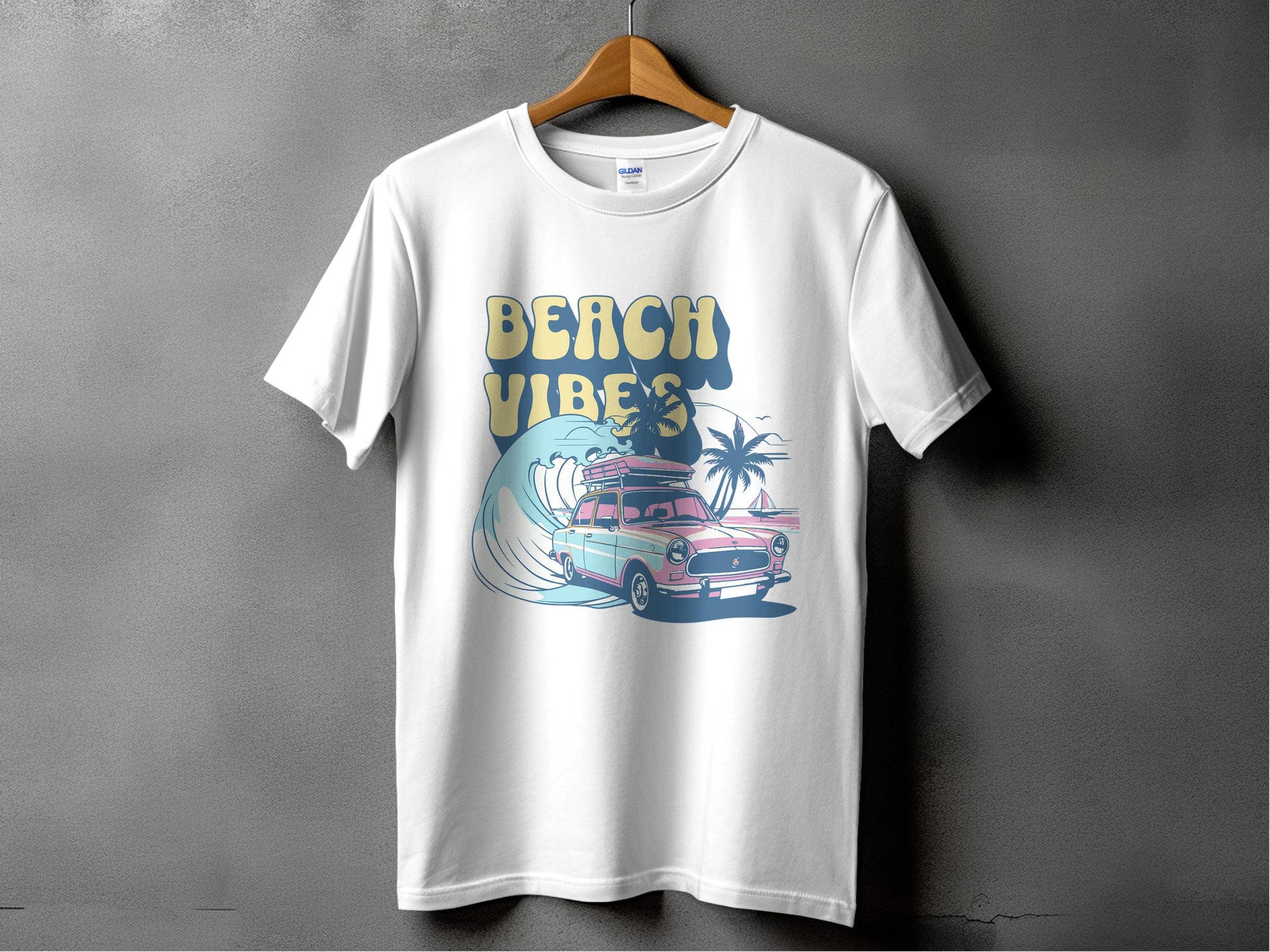 Garment Graphics white t-shirt features a classic car with surfboards on top and palm trees behind, with a retro font boldly announcing Beach Vibes to capture the essence of sun-soaked adventures.
