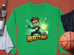 A vibrant green Its Herotime sweatshirt by Garment Graphics features a cartoon superhero with brown hair and a matching green mask, emitting dynamic energy from their hand. Ideal for adventurous youth, this colorful design rests on a sports surface surrounded by gym items.